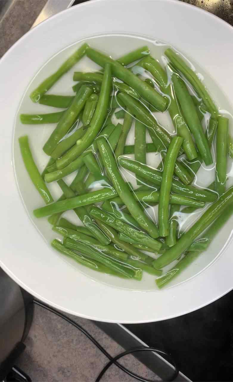 Grüne Bohnen nach dem Kochen in kaltem Wasser abschrecken