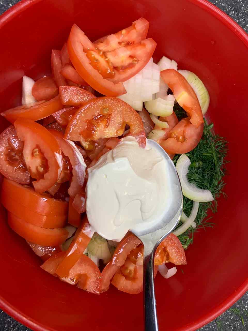 2 Esslöffel Schmand in den Tomatensalat geben